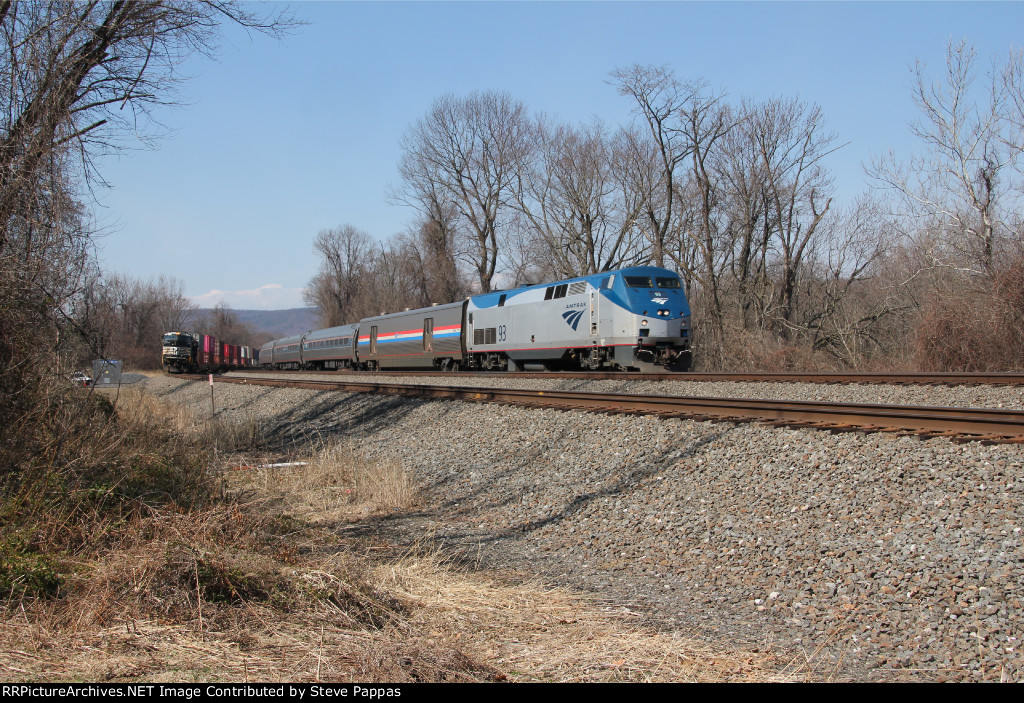 Amtrak 93 takes train 04T past a train waiting on the siding